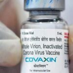 A vial of the Covaxin vaccine is being displayed by a medical worker.