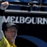 Jannik Sinner wiping sweat from his face during a match at the Australian Open in extreme heat