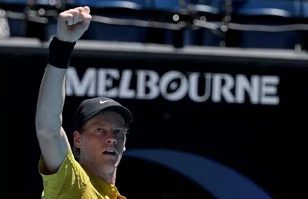Jannik Sinner wiping sweat from his face during a match at the Australian Open in extreme heat