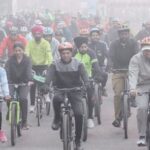 Cyclists commuting on a busy Delhi street, highlighting the need for safer roads and dedicated cycle lanes.